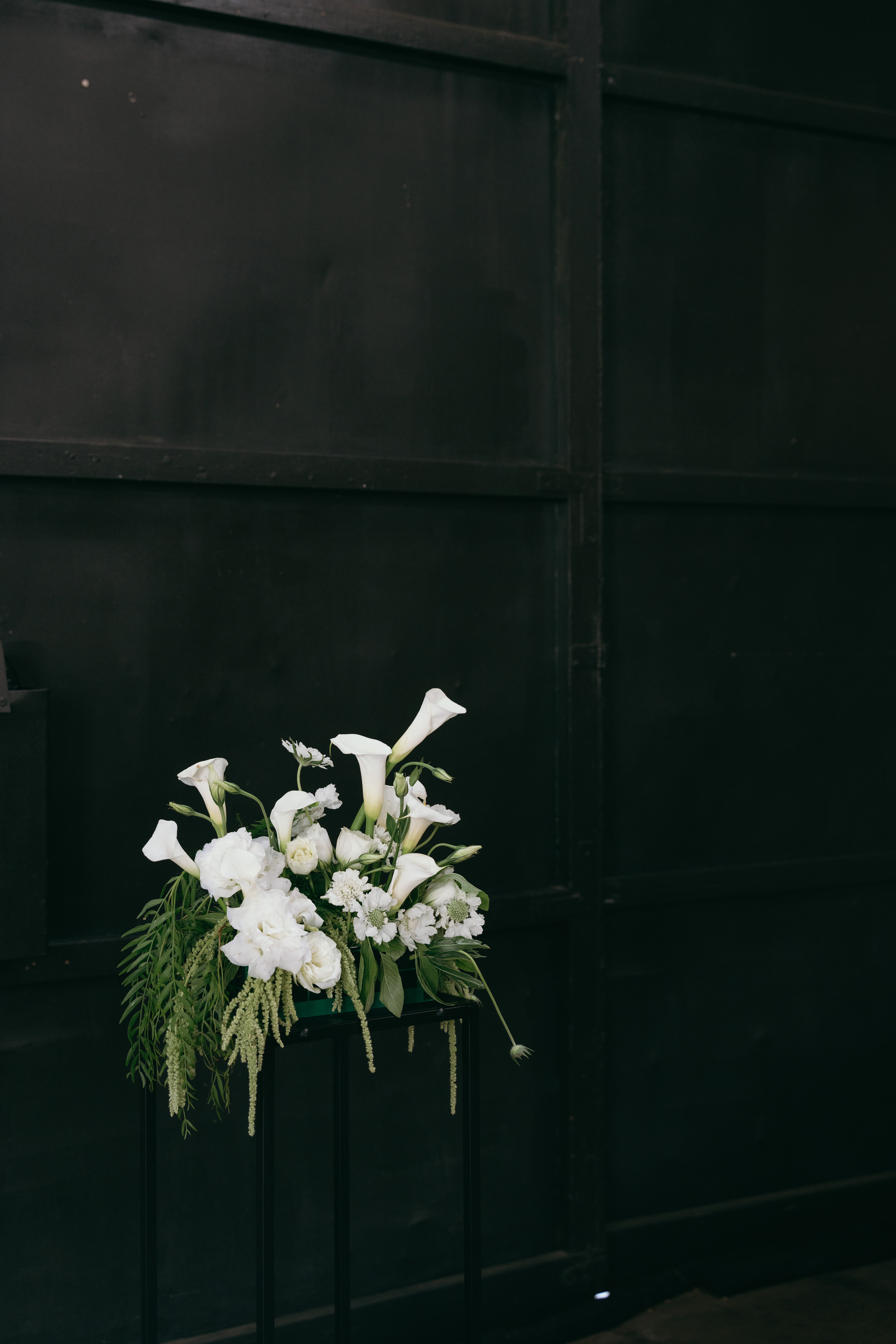 White bridal bouquet against dark green doors