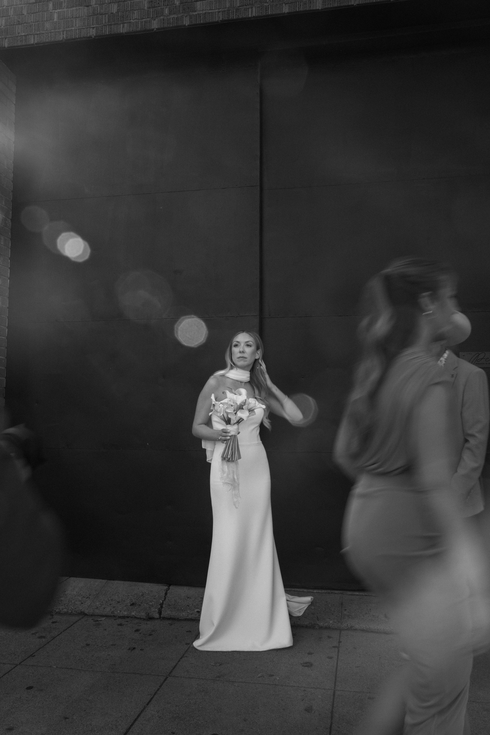 A bride holding her bouquet as guests pass in front